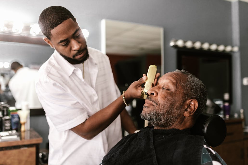 Barber using trimmer on client in a barbershop, capturing a moment of precision and care.